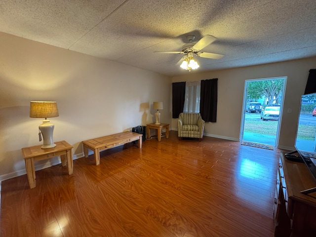 sitting room with a textured ceiling, hardwood / wood-style flooring, and ceiling fan