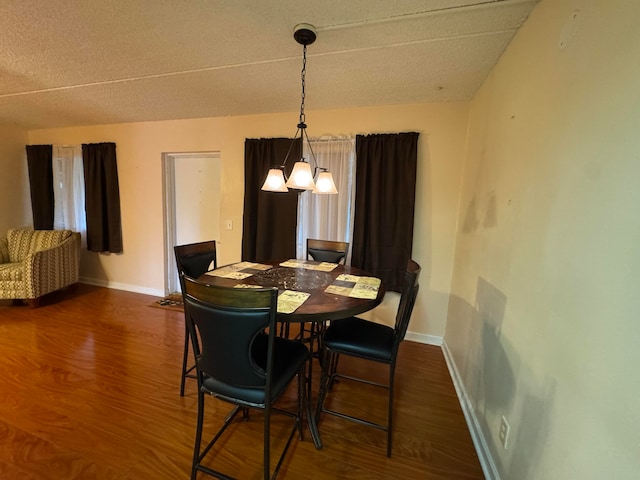 dining room featuring a chandelier, a textured ceiling, and dark hardwood / wood-style flooring