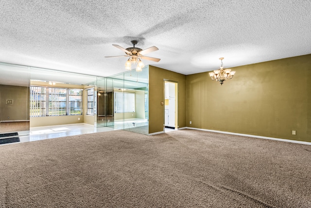 carpeted empty room featuring ceiling fan with notable chandelier and a textured ceiling