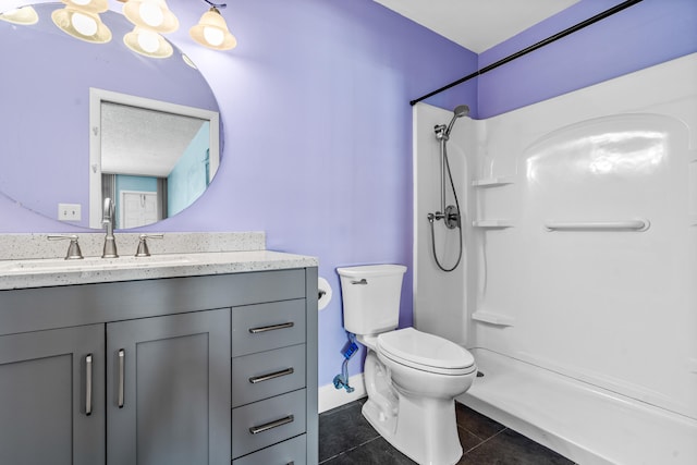 bathroom with a shower, tile patterned flooring, vanity, and toilet