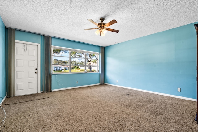 spare room with a textured ceiling, carpet floors, and ceiling fan