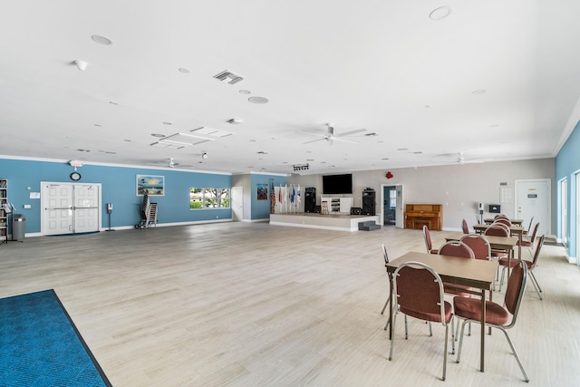 dining area featuring ceiling fan, light wood-type flooring, and ornamental molding