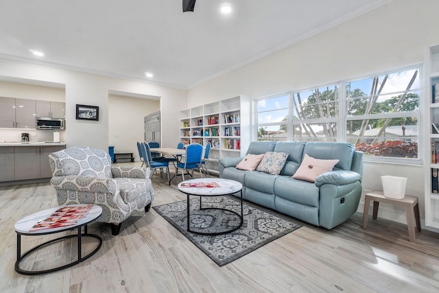 living room featuring light wood-type flooring and ornamental molding