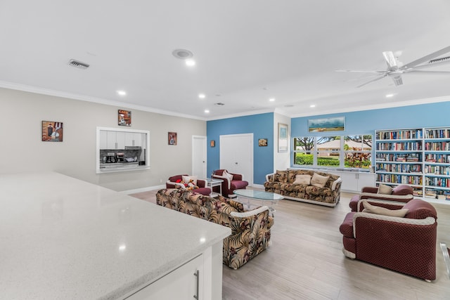 living room featuring ceiling fan, light wood-type flooring, and crown molding