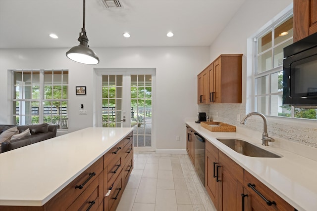 kitchen featuring backsplash, a healthy amount of sunlight, sink, and stainless steel dishwasher