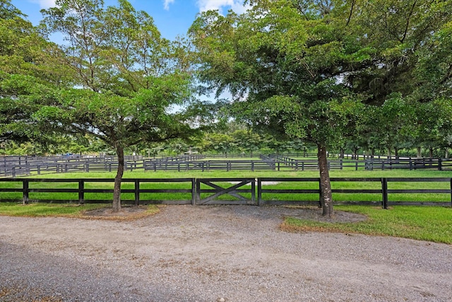 view of gate with a yard and a rural view