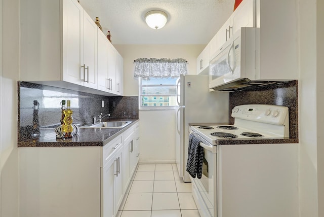 2145 Pierce St Unit 326, Hollywood, FL 33020 - kitchen with white appliances, a sink, dark countertops, backsplash, and white cabinets