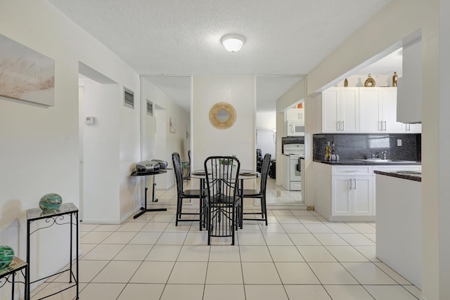 2145 Pierce St Unit 326, Hollywood, FL 33020 - kitchen featuring dark countertops, white appliances, decorative backsplash, white cabinetry, and a sink