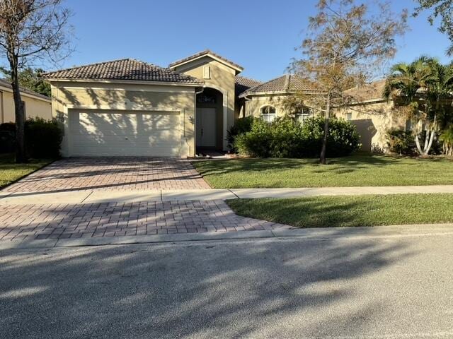 mediterranean / spanish house featuring a front lawn and a garage