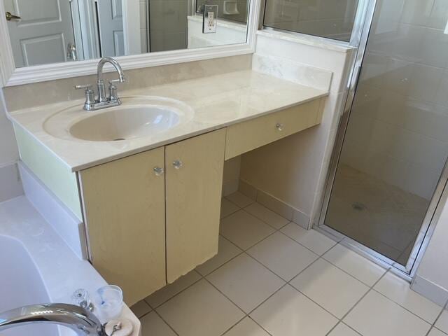 bathroom featuring a shower with door, vanity, and tile patterned floors