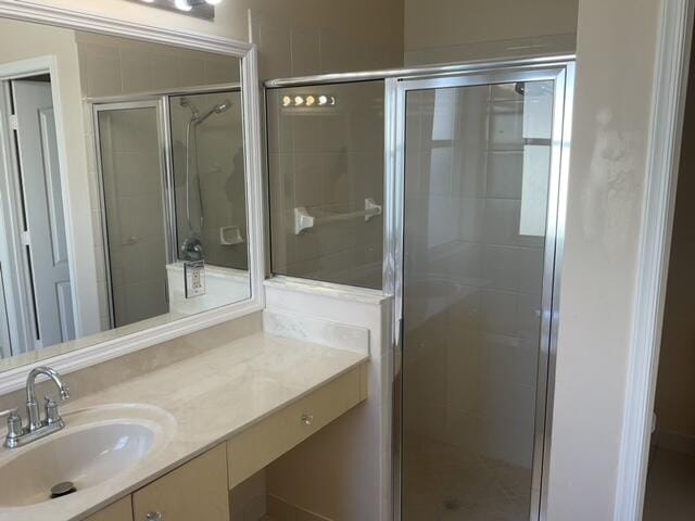 bathroom featuring vanity and a shower with door