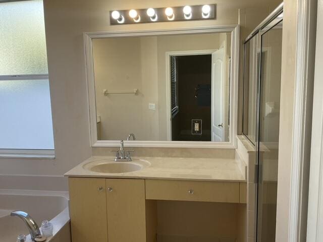 bathroom featuring vanity and shower with separate bathtub