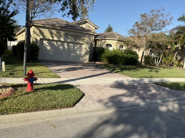 mediterranean / spanish-style home featuring a front yard and a garage