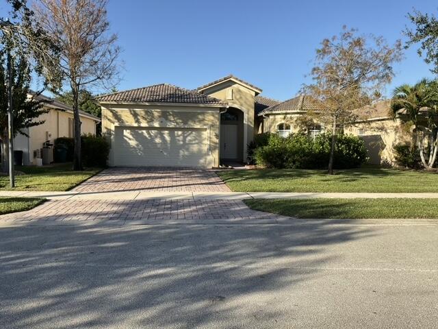 mediterranean / spanish house with a front lawn and a garage