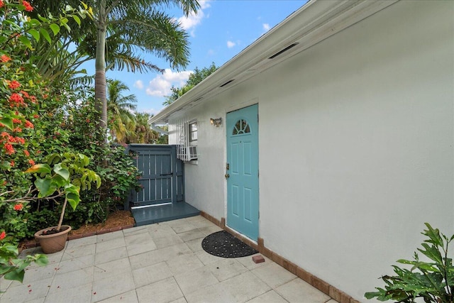 502 39th St, West Palm Beach, FL 33407 - property entrance with stucco siding, a gate, and a patio