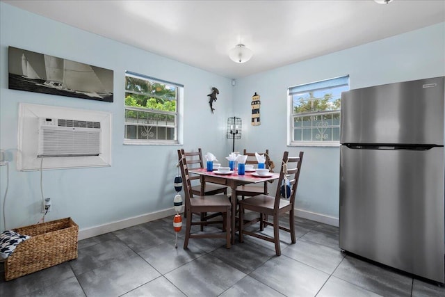 dining area with dark tile patterned flooring and a healthy amount of sunlight