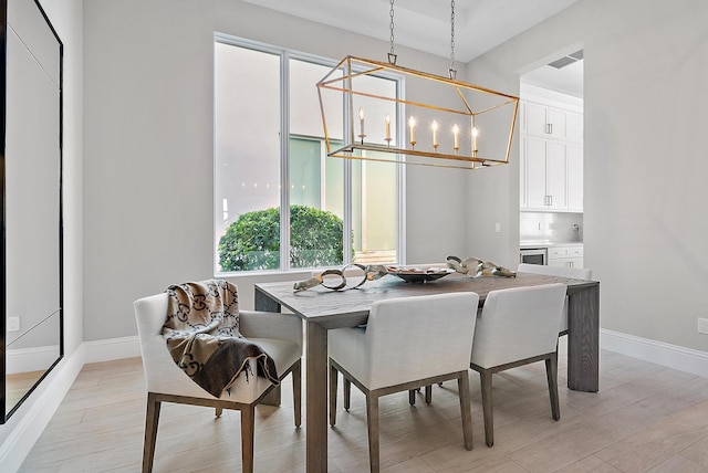 dining space featuring a notable chandelier and light hardwood / wood-style flooring