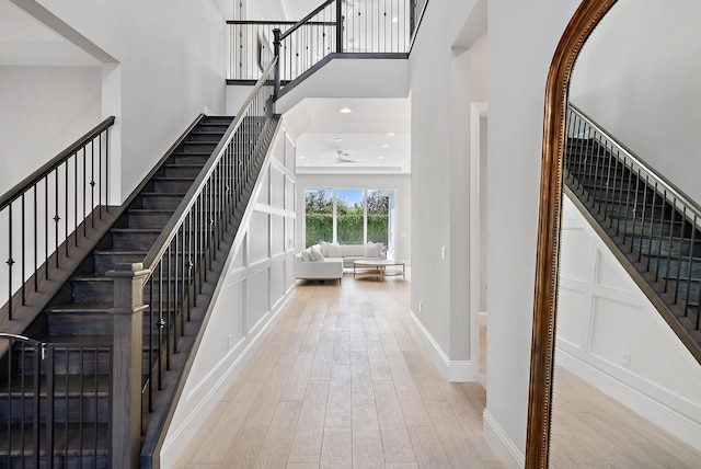 stairway featuring hardwood / wood-style flooring and a towering ceiling