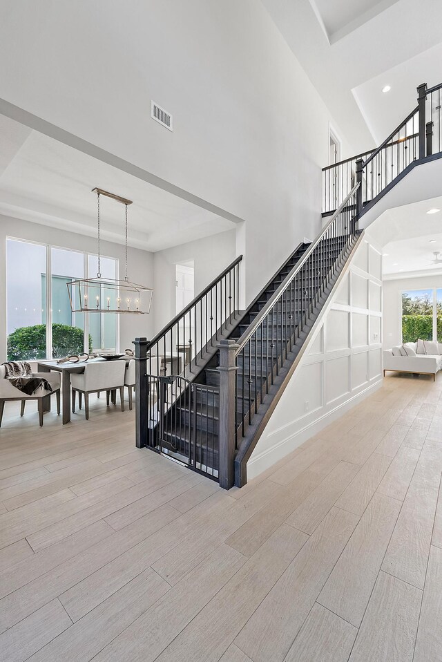 stairway with a chandelier and hardwood / wood-style flooring