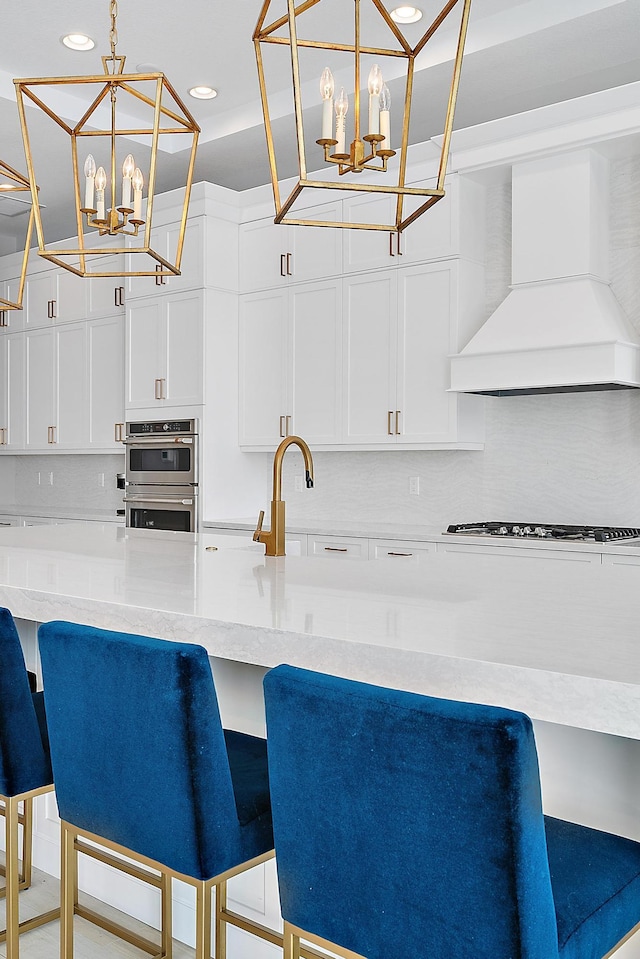 kitchen featuring a kitchen bar, custom range hood, and decorative light fixtures