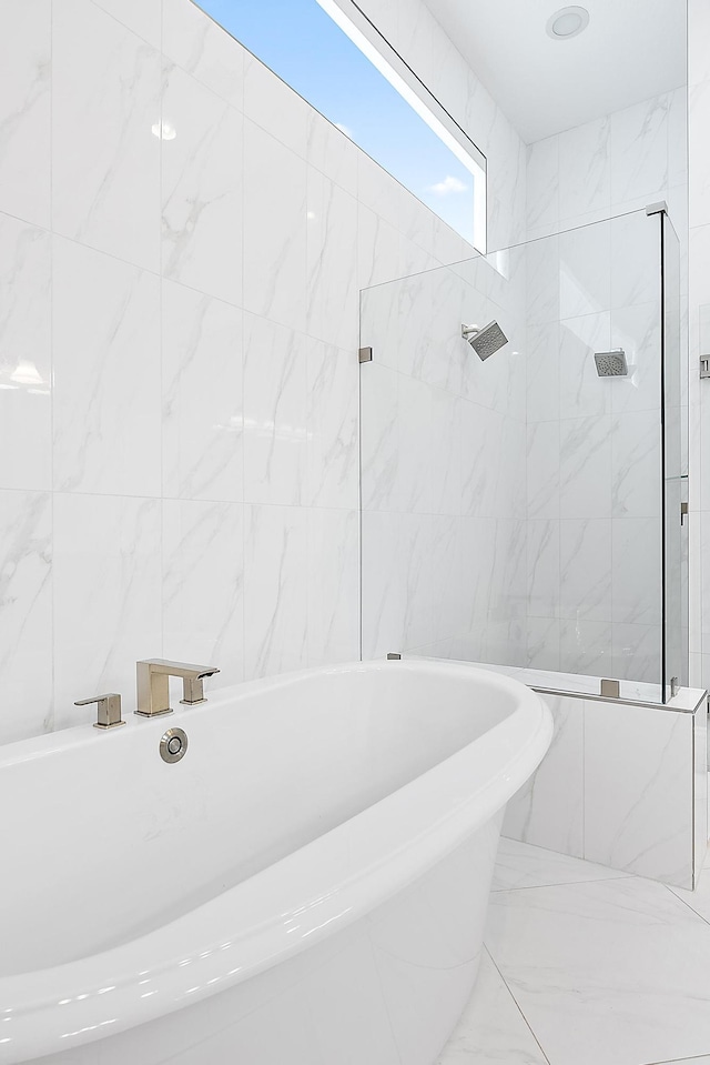 bathroom featuring tile walls and independent shower and bath