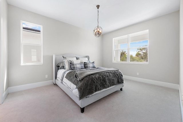 bedroom featuring a chandelier and light colored carpet