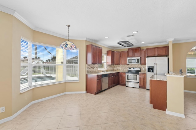 kitchen with appliances with stainless steel finishes, hanging light fixtures, and plenty of natural light