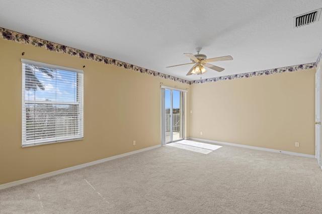 carpeted empty room with a textured ceiling and ceiling fan