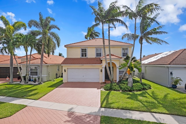 mediterranean / spanish-style home featuring a front yard and a garage