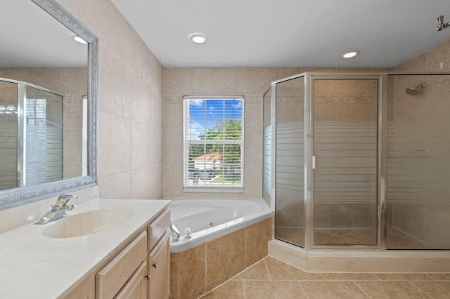 bathroom featuring tile walls, vanity, plus walk in shower, and tile patterned floors