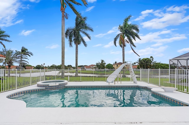 view of swimming pool featuring an in ground hot tub and a water slide