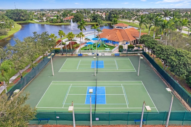 view of tennis court featuring a water view