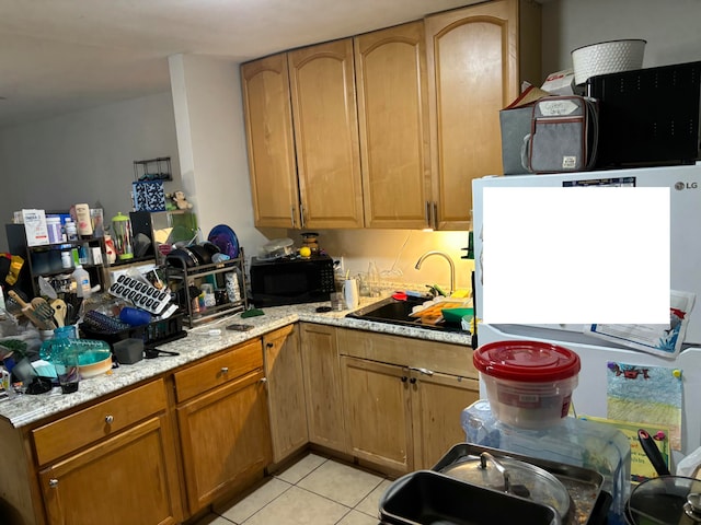 kitchen featuring sink, light stone counters, and light tile patterned floors