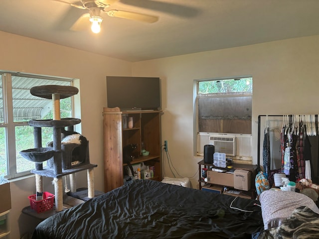 bedroom featuring cooling unit, multiple windows, and ceiling fan