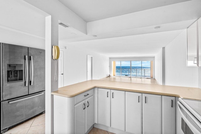 kitchen with white cabinetry, electric stove, light tile patterned flooring, and stainless steel fridge with ice dispenser