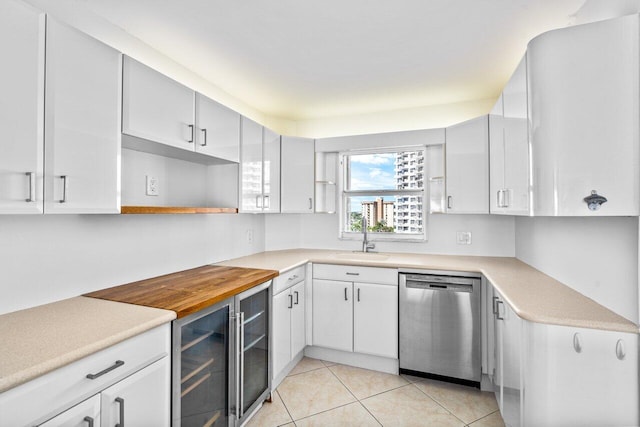 kitchen with sink, dishwasher, white cabinets, and light tile patterned flooring