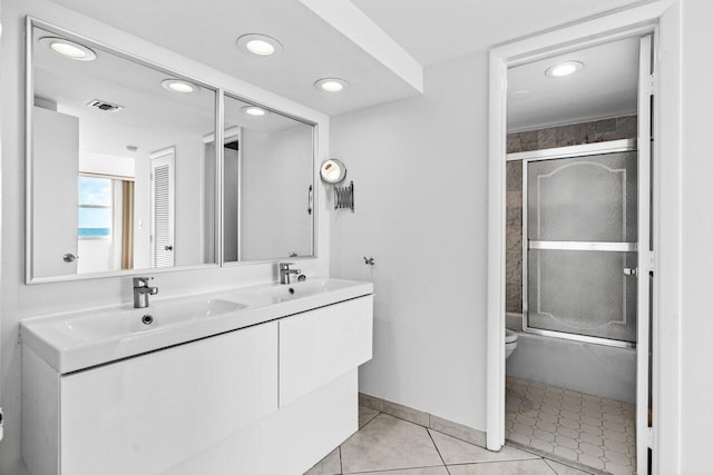 full bathroom featuring vanity, toilet, tile patterned flooring, and bath / shower combo with glass door