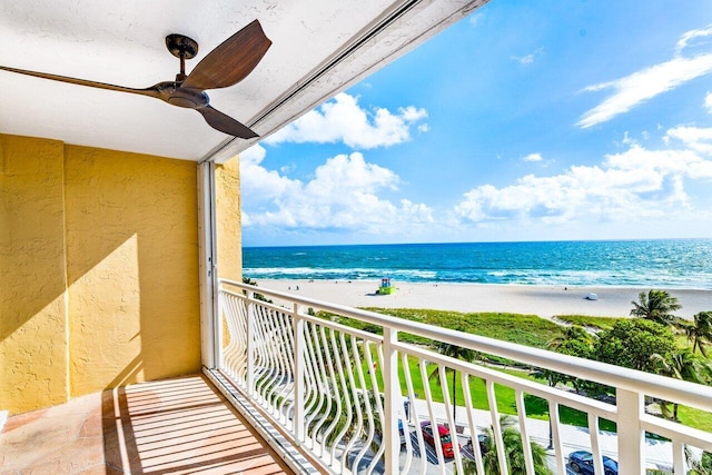 balcony with a water view, a beach view, and ceiling fan