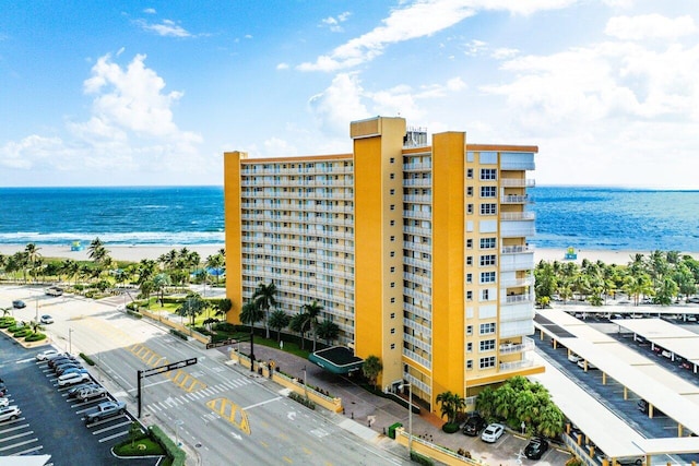 view of building exterior featuring a water view and a view of the beach