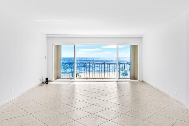 tiled spare room with a water view