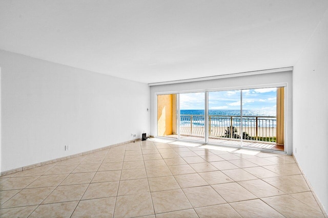 tiled spare room with a water view