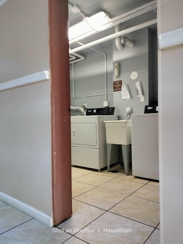 washroom featuring washer and clothes dryer and light tile patterned flooring