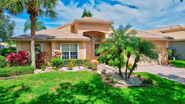 mediterranean / spanish house featuring a front yard and a garage