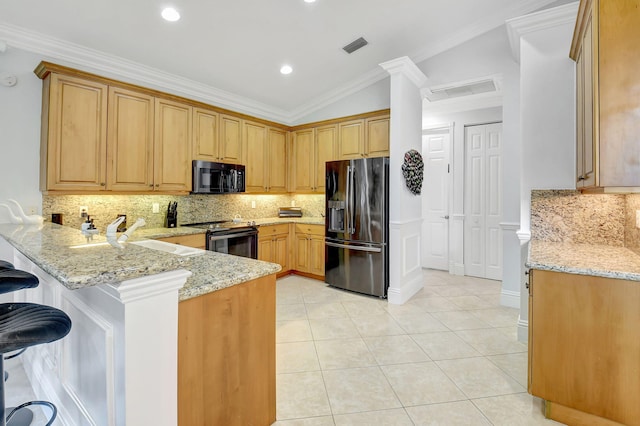 kitchen featuring kitchen peninsula, light stone counters, vaulted ceiling, sink, and stainless steel appliances