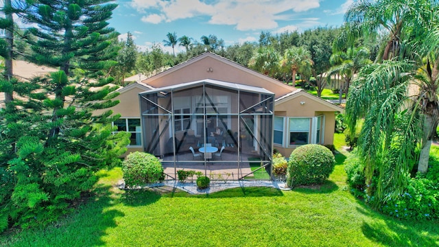 back of property featuring a sunroom and a lawn