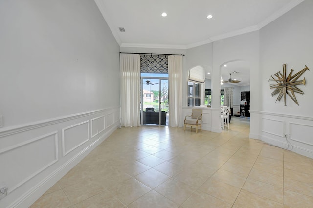 tiled empty room with crown molding and ceiling fan