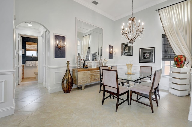 tiled dining space with a notable chandelier, ornamental molding, and a wealth of natural light