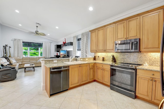 kitchen featuring stainless steel appliances, ornamental molding, sink, vaulted ceiling, and ceiling fan