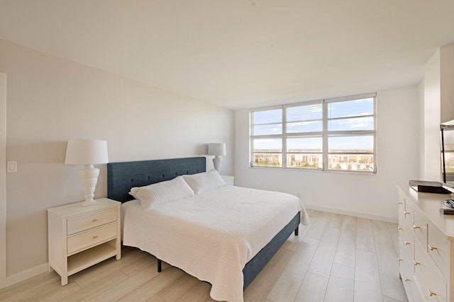 bedroom with light wood-style flooring and baseboards