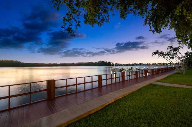 view of dock featuring a water view and a lawn